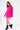 Brooke hot pink oversized knit sweater with trendy elbow cut-outs, styled with black platform boots on white background.