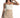 Model wearing the white Emmie Strapless Bustier, a structured corset-style crop top paired with beige trousers.