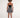 Back view of the Nika black sleeveless crop top with silver chain straps, paired with a patterned black and white mini skirt.