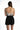 Back view of woman in Harmoni grey tie-dye seamless bodysuit and black denim shorts, highlighting the chic scoop back.