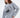 Model wearing an oversized light grey streetwear sweatshirt with a black circular nautical sailing ship graphic.