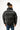 Rear view of Brooks black puffer coat featuring an oversized minimalist design and high collar for winter streetwear style.