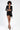 Model in Ruby black mini dress with satin blazer lapels, shoulder pads, and waist tie sash for trendy evening wear.