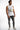 Model in a Successful white ribbed tank with streetwear graphics, paired with distressed grey jeans and white sneakers.