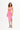 Model in pink bodycon midi dress with waist cutout, side slit, and halter straps against white studio background.