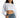 Model in Stevie white long sleeve ribbed crop top with crew neck and cuffed sleeves, paired with high-waist blue jeans.