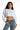 Model in Stevie white long sleeve ribbed crop top with crew neck and cuffed sleeves, paired with high-waist blue jeans.