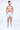 Model wearing Walker white swim trunks with a blue sailboat pattern and white Carbon brand slides on a white background.