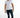 A man stands confidently in a fitted white t-shirt and distressed dark jeans, paired with white sneakers.