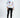 A model wearing a long-sleeve white shirt with colorful graphics and black ripped jeans, paired with sneakers.