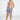 Model wearing Hank Swimwear blue floral patterned swim trunks with white drawstrings and Carbon Jeans slides.