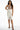 Model wears the Carbon Evie Sleeveless Bodysuit with a high-waisted belted white skirt and black strappy heels.