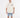 A man wearing a beige oversized t-shirt with graphic prints, paired with denim shorts and white sneakers.
