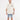 A man wearing a beige oversized t-shirt with graphic prints, paired with denim shorts and white sneakers.