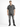 A man stands wearing a short-sleeve black and white checkered shirt paired with distressed gray jeans and black sneak...
