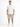 A man stands wearing a loose-fitting white t-shirt with text, paired with beige cargo shorts and sneakers.