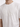 White t-shirt featuring a textured, embossed "PEACE" design on the front, worn by a model.