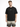 A man stands wearing a black oversized t-shirt with white text, paired with light ombre shorts.
