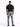 A person stands with their back to the camera, wearing a black t-shirt and gray jeans, paired with black shoes.