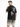 A man wearing a black t-shirt with a graphic design featuring a devilish cherub and a skull on the back.