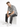 A man sits on a white pedestal wearing a black and white patterned short-sleeve shirt and distressed gray jeans.