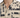Close-up of a short-sleeve shirt featuring a beige fabric with bold black abstract patterns and a buttoned placket.