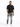 A man stands confidently in a black t-shirt and distressed gray jeans, paired with white sneakers.