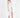 A model poses in a fitted white dress with a high slit, paired with nude block-heeled sandals.
