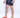 Jaxon men's black floral swim trunks with white leaf patterns and red logo slides, side view.