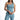 Model wearing light blue Karina Crop Tank, a one-shoulder sleeveless top with asymmetrical neck on white background.