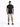 A man stands with his back to the camera, wearing a black t-shirt and light gray shorts.