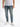 A man wearing light blue distressed jeans and white sneakers, standing against a plain background.