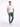 A man stands confidently in a fitted white t-shirt and distressed blue jeans, paired with white sneakers.