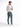 A man in a fitted white t-shirt and blue jeans stands with his back to the camera, showcasing casual footwear.