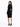 A woman in a fitted black dress with long sleeves, standing in high heels and looking over her shoulder.