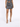 A model showcases a fitted, sparkly dress with a cut-out design, paired with strappy high-heeled sandals.