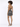 A model showcases a backless, shimmering silver dress with thin straps and stylish high heels.