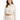 A woman models a cropped, cream-colored hoodie with a drawstring and relaxed fit, paired with matching pants.