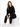A woman sits on a white cube wearing a black hoodie and matching joggers, paired with white sneakers.