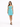 A woman stands in a light blue dress with cut-out details, paired with black strappy heels and a bracelet.