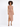 A model showcases a fitted, sleeveless dress with a side cutout and thigh-high slit, paired with strappy heels.