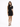 A woman poses in a fitted black dress with a high neckline and a cutout on one shoulder, paired with black heels.