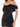 A close-up of a woman wearing a black off-shoulder dress with a ruched design and soft fabric.