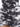 Close-up of a ruched black and white dress featuring a tie detail, showcasing a cloud-like pattern and textured fabric.