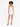 A model poses in a fitted white dress with thin straps, showcasing a sleek silhouette and stylish black heels.