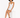 A model with curly hair sits on a white block, wearing a fitted white dress and black strappy heels.