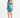 A model poses in a vibrant blue and green one-shoulder dress with a cutout and ruched detailing.