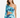 A model poses in a colorful, abstract-patterned crop top with one long sleeve and a matching skirt.