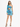 A model poses in a vibrant blue and teal one-shoulder dress with a fitted silhouette and ruched detailing.