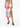 A model wearing a colorful floral print skirt with a thigh-high slit, paired with black heeled mules.